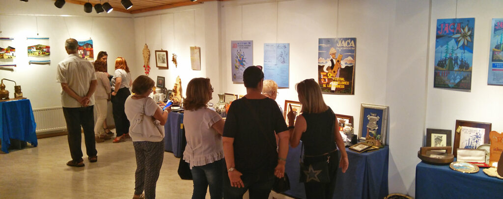 La exposición recoge una selección de los recuerdos recibidos por el Festival de manos de los grupos participantes a lo largo de toda su historia y se ha puesto en marcha con la colaboración de la Asociación Doña Sancha de Jaca.